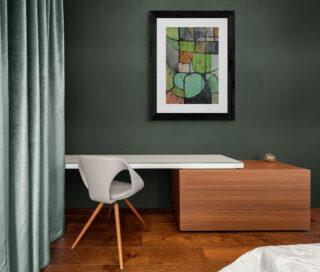 Współczesny obraz artystyczny oprawiony w czarną ramę z białym passe-partout wisi w zielonej sypialni. Malarstwo wykonane w technice gwaszu na papierze. Dzieło inspirowane stylem postindustrialnym i loftowym.